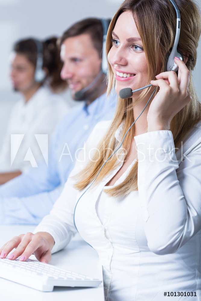 A woman wearing white dress and a headset talking with a customer.